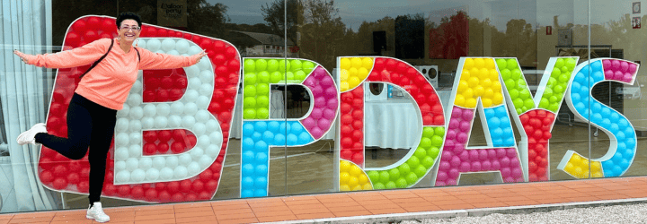 partecipante del BPDAYS sorridente che scatta una foto davanti ad una scultura di palloncini
