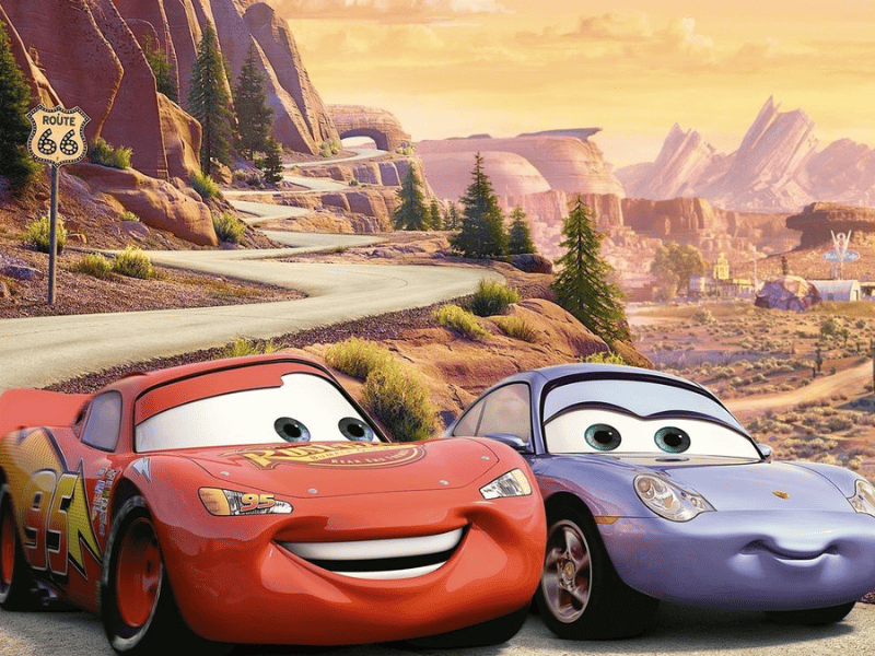 Saetta McQueen e Sally che sorridono mentre guidano sulla route 66