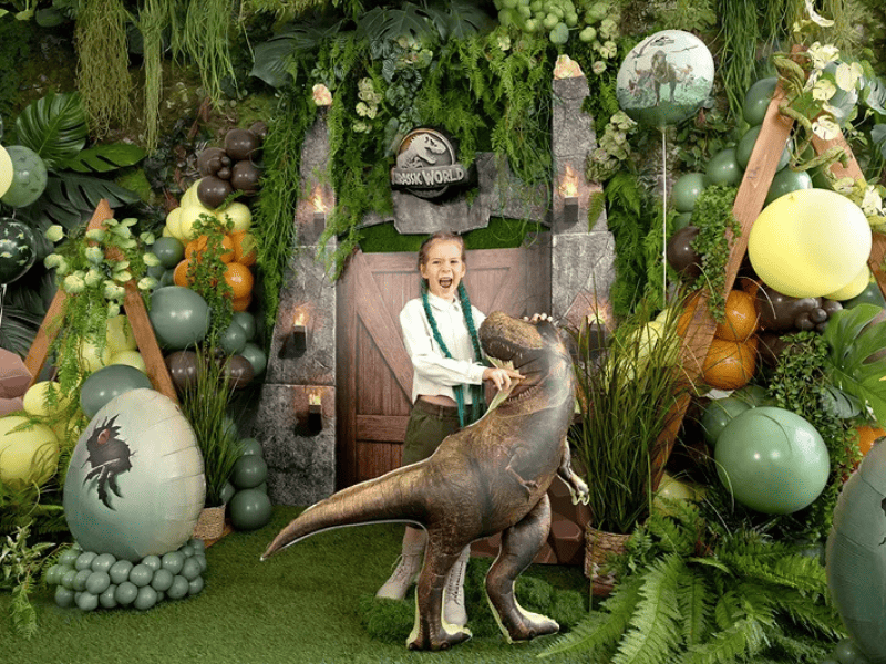 Decorazioni festa dinosauri con palloncini e allestimento giungla per compleanno