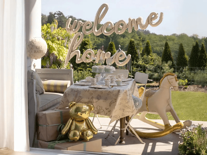 ambientazione con decorazioni di palloncini in foil con scritto "welcome home" per aspettare a casa una nascita