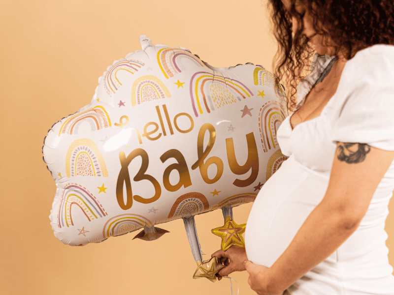 donna che festeggia capodanno con dei palloncini color oro e argento
