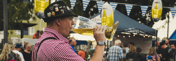 signore vestito a tema oktoberfest che beve birra